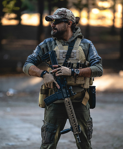 man dressed in tactical attire holding a rifle